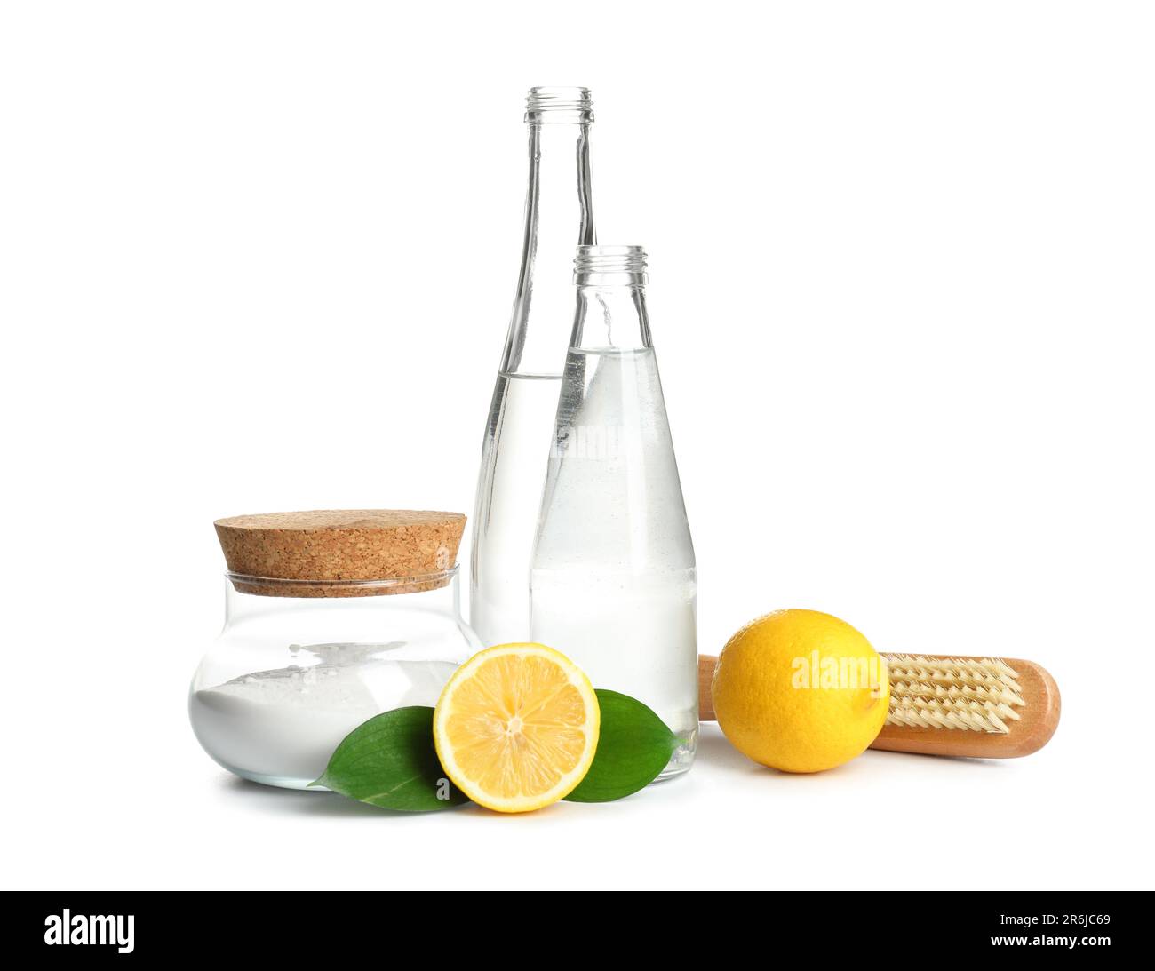 Bottles of vinegar, baking soda, brush and lemons on white background ...