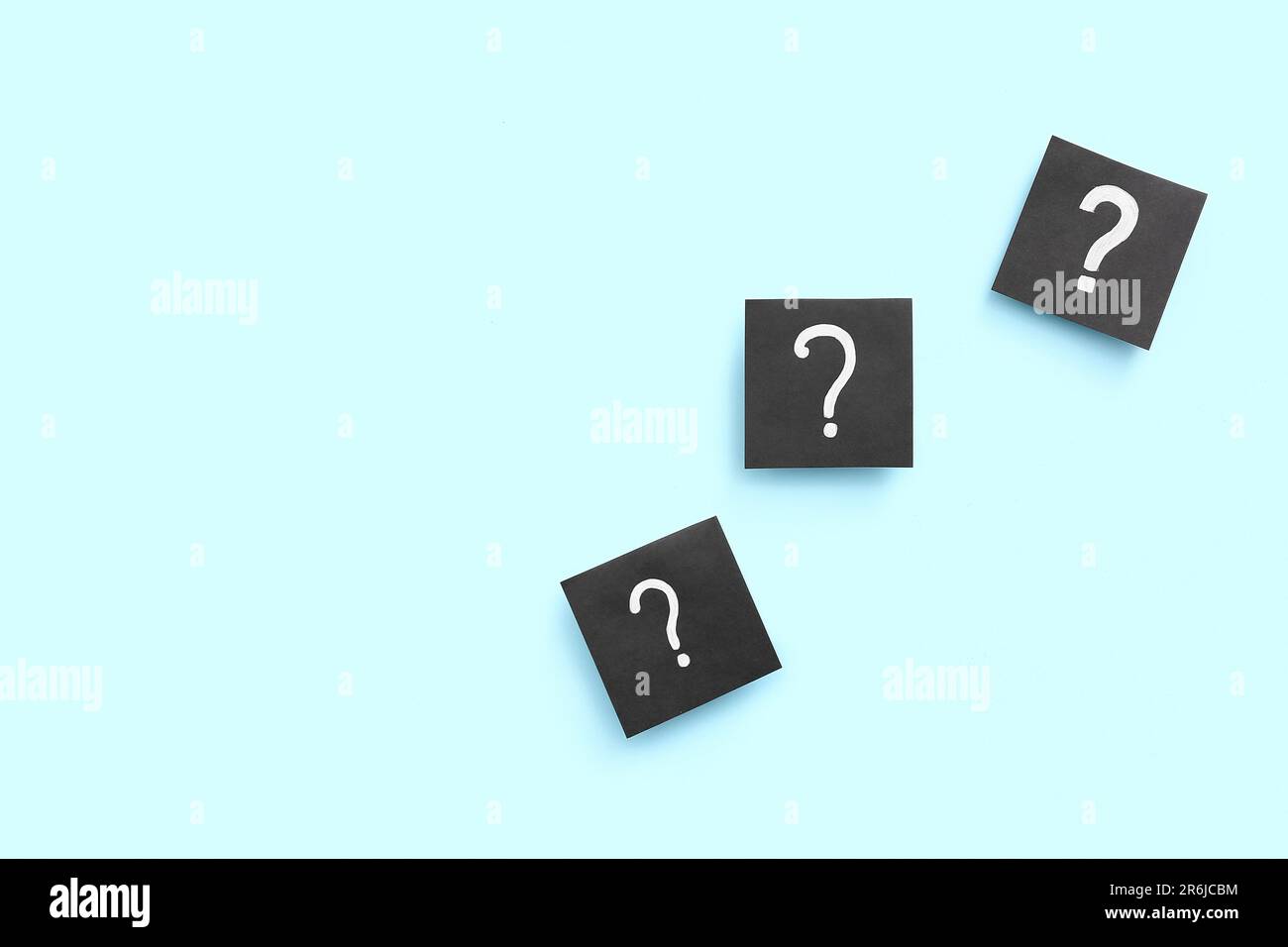 Papers with question marks on blue background Stock Photo - Alamy