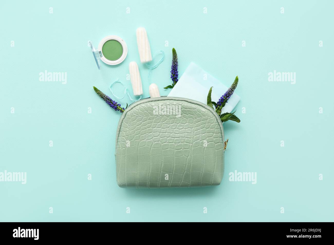 Lady's cosmetic bag with eyeshadows, menstrual pad and tampons on