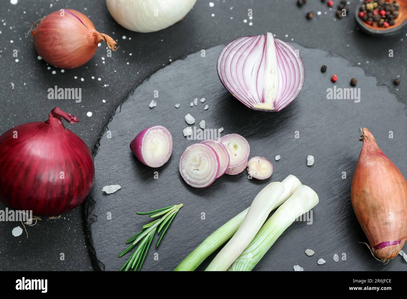 Board with different kinds of onion on grunge black background Stock ...