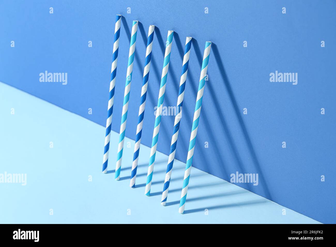 Different paper drinking straws on blue background Stock Photo