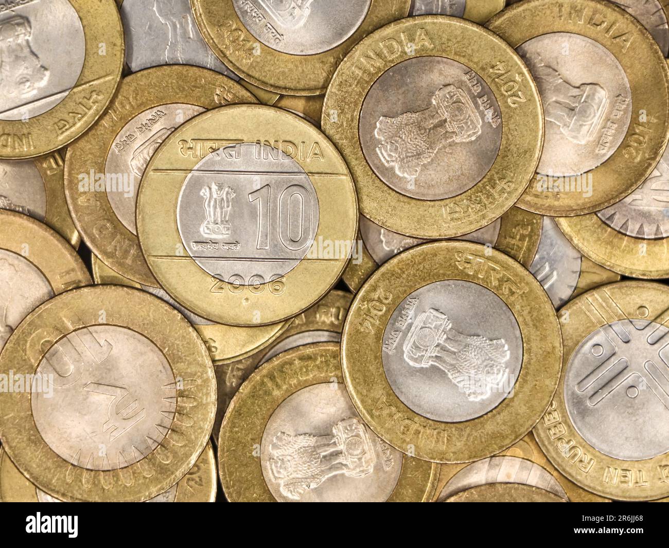 a mixed collection of rare vintage indian bimetallic 10 (ten) rupee coins gold and silver in a pile Stock Photo