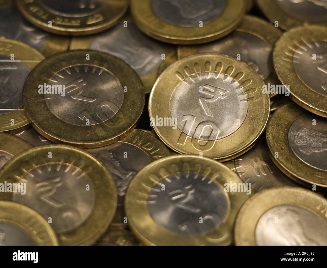 a mixed collection of rare vintage indian bimetallic 10 (ten) rupee coins gold and silver in a pile Stock Photo