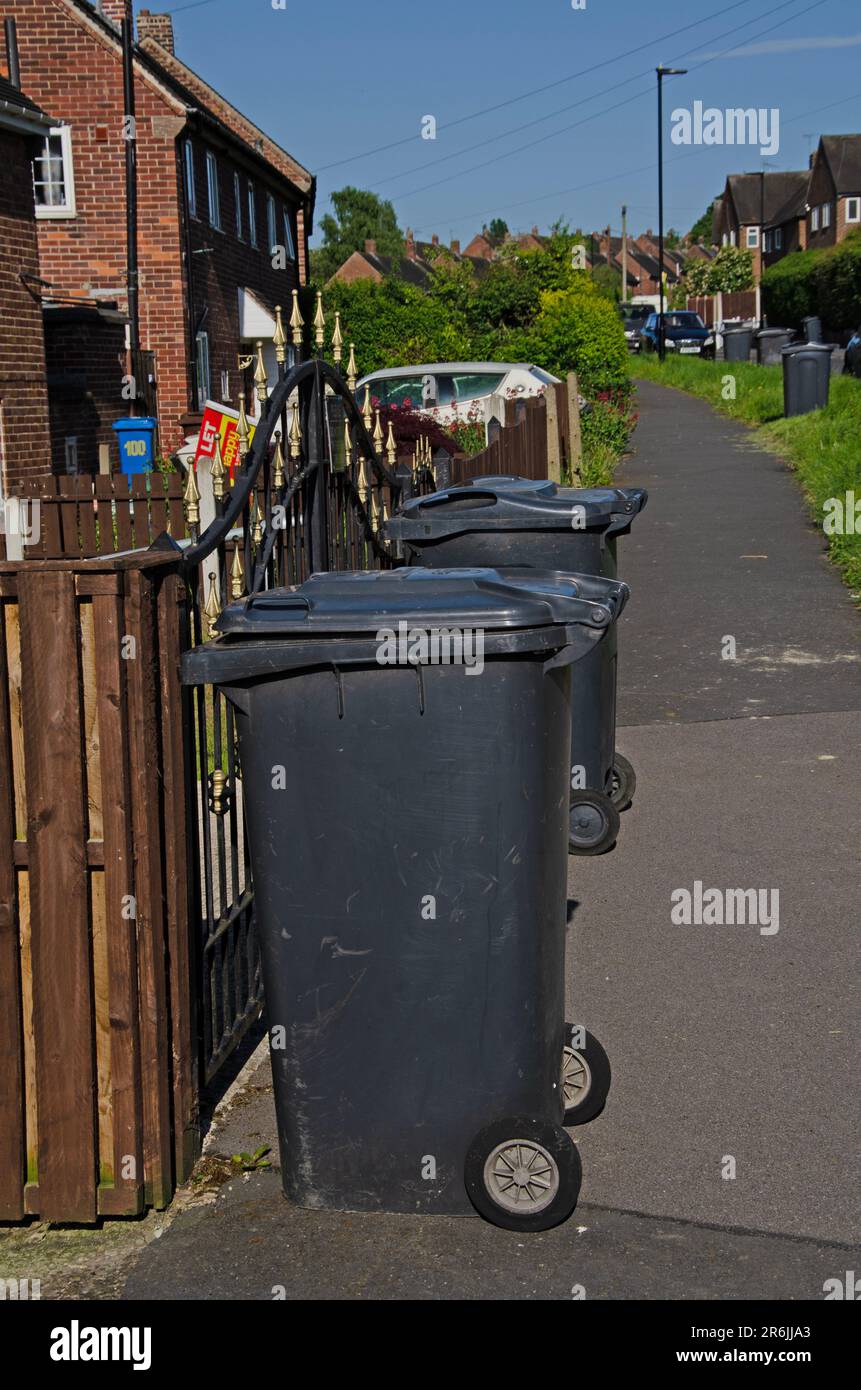 Black bin on pavement collection day. Full frame image of black bins