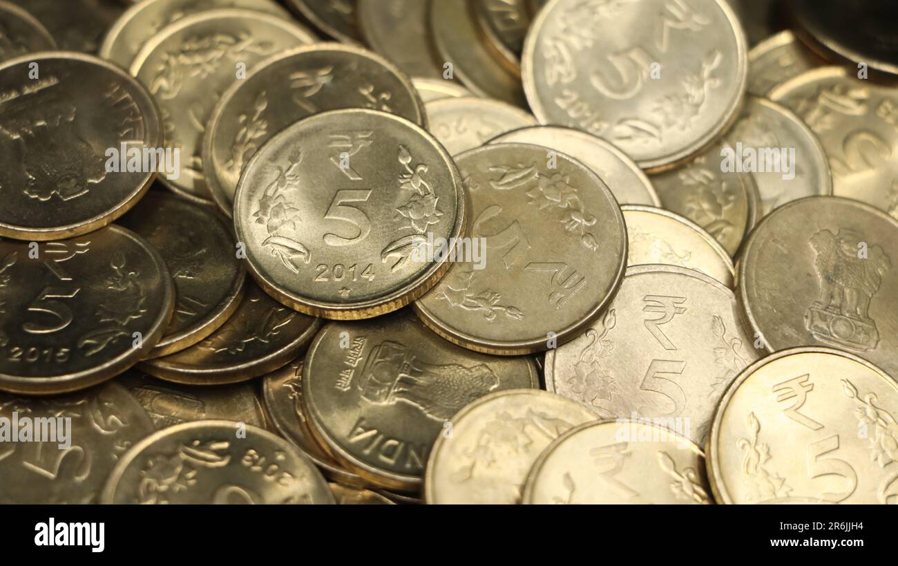 closeup shot of a collection of vintage golden 5 or five rupees in a pile of authentic indian coins Stock Photo