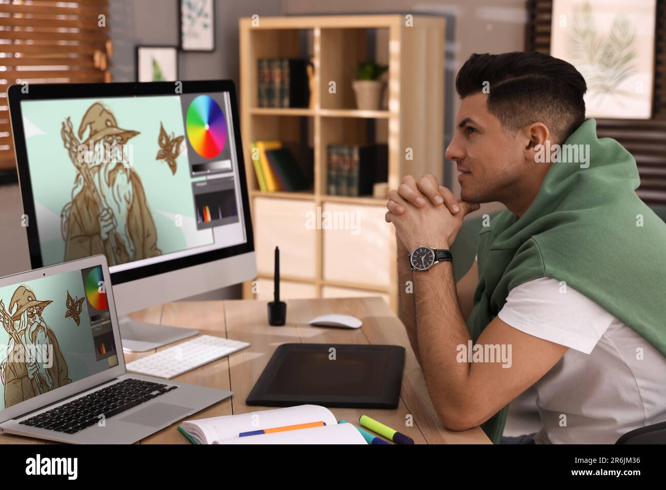 Animator working with computer and laptop. Illustrations on screens Stock Photo