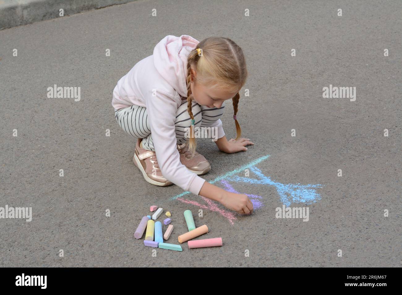 Little child drawing happy family with chalk on asphalt Stock Photo - Alamy