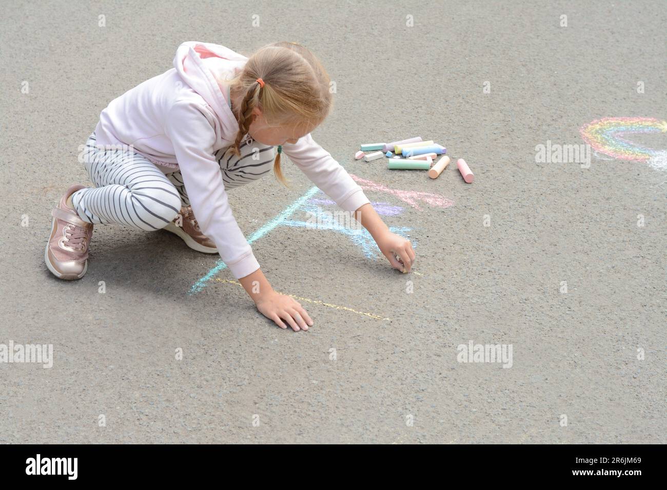Little child drawing happy family with chalk on asphalt Stock Photo - Alamy