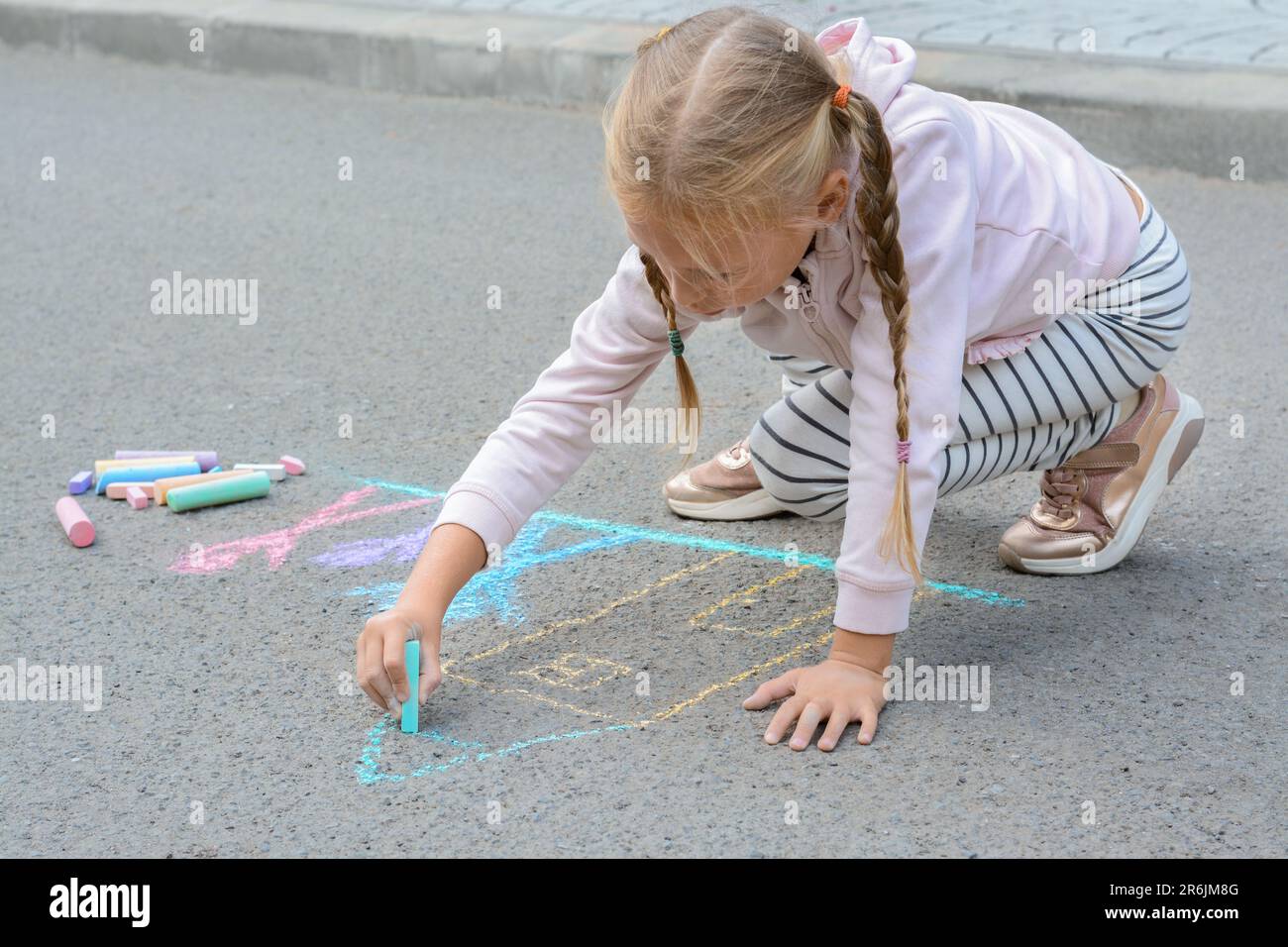 Little child drawing happy family with chalk on asphalt Stock Photo - Alamy