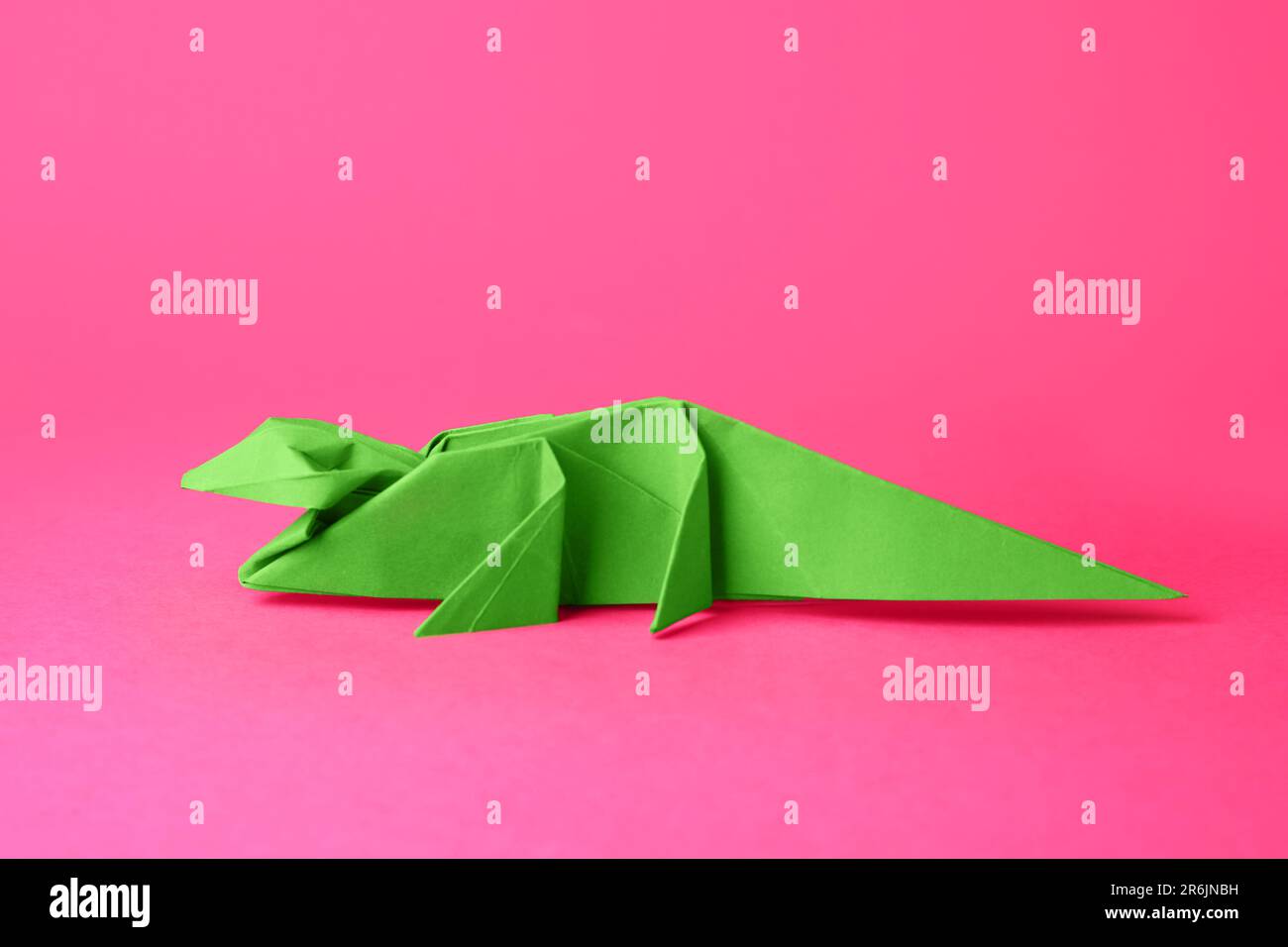 Origami art. Handmade green paper crocodile on pink background Stock ...
