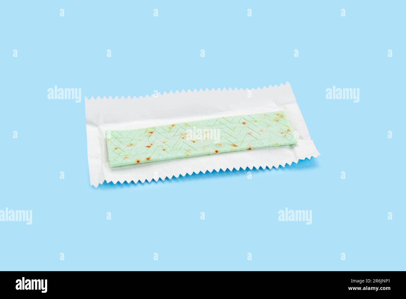 Unwrapped stick of chewing gum on light blue background Stock Photo