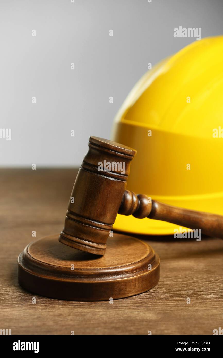 Construction and land law concepts. Gavel and hard hat on wooden table Stock Photo