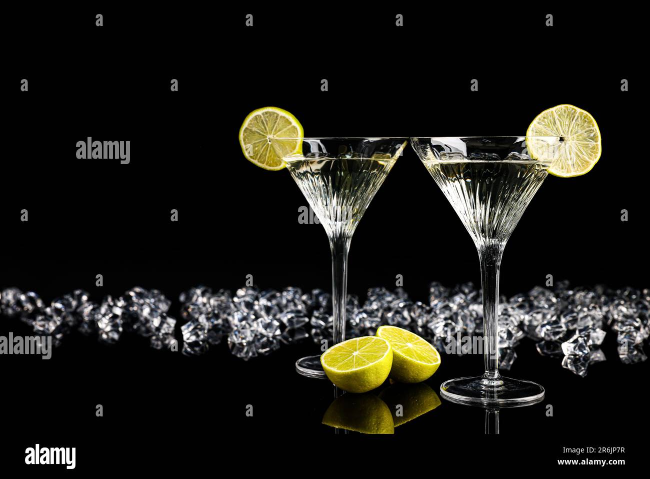 https://c8.alamy.com/comp/2R6JP7R/two-glasses-of-martini-cocktail-and-ice-cubes-on-black-background-space-for-text-2R6JP7R.jpg