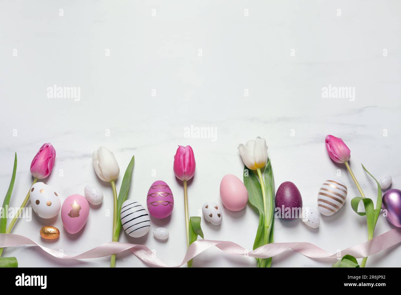Flat lay composition of painted Easter eggs and tulip flowers on white ...