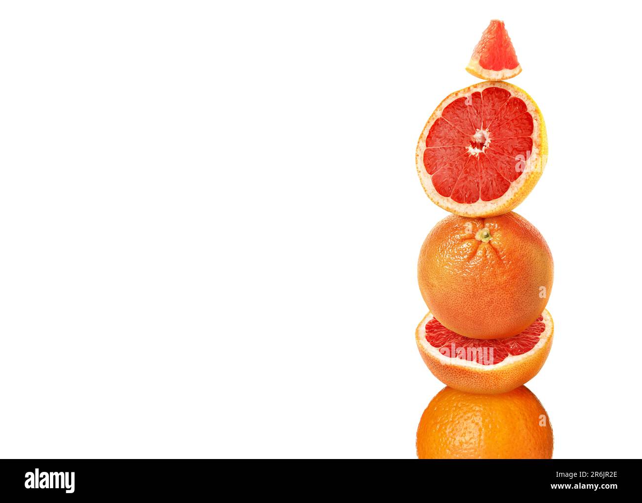 Stacked cut and whole grapefruits on white background Stock Photo