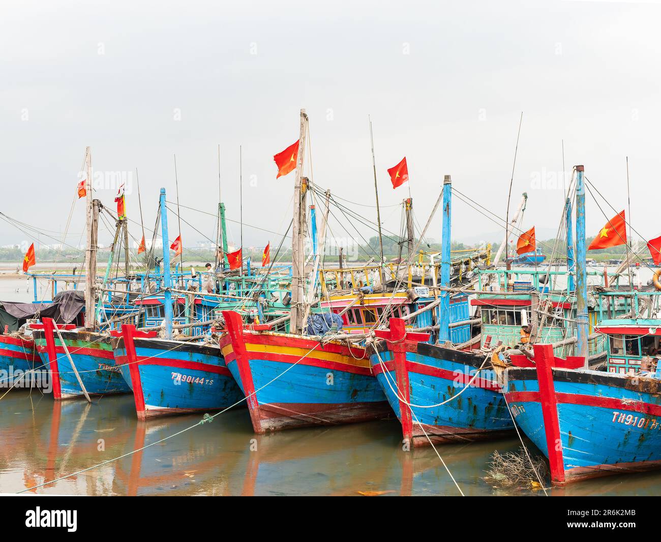 Fishing boats moored at low tide on Song Lang Giang, Lang Giang River, in Quong Nham, Vietnam Stock Photo