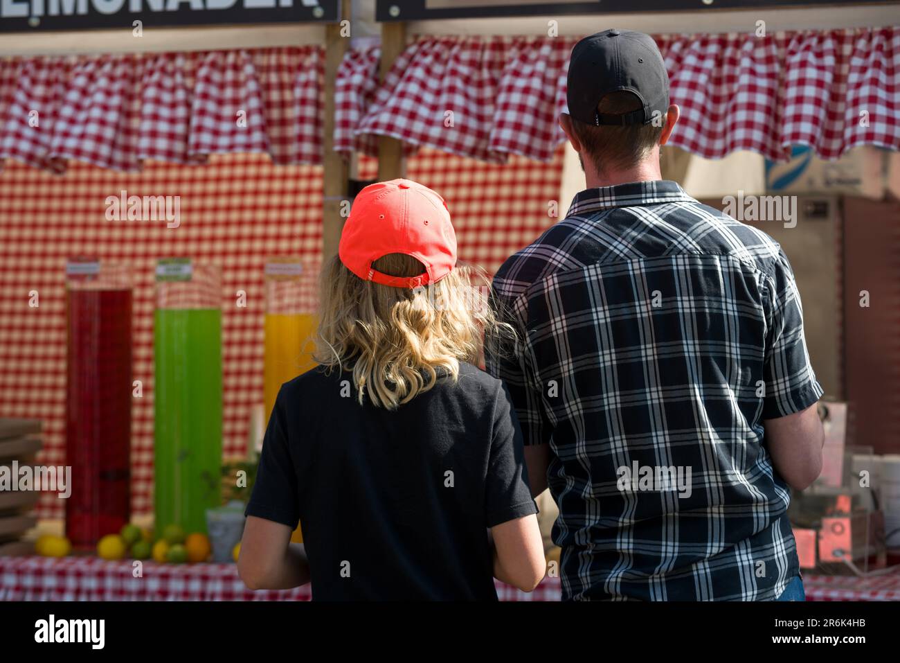 Couple in front of fair stall. Checkered pattern Stock Photo