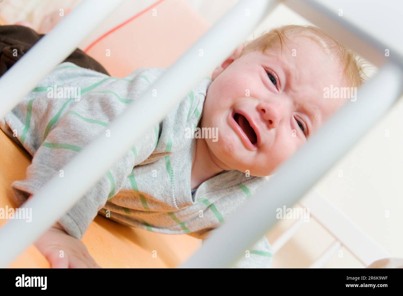 Toddler crying in a cosy cot Stock Photo Alamy