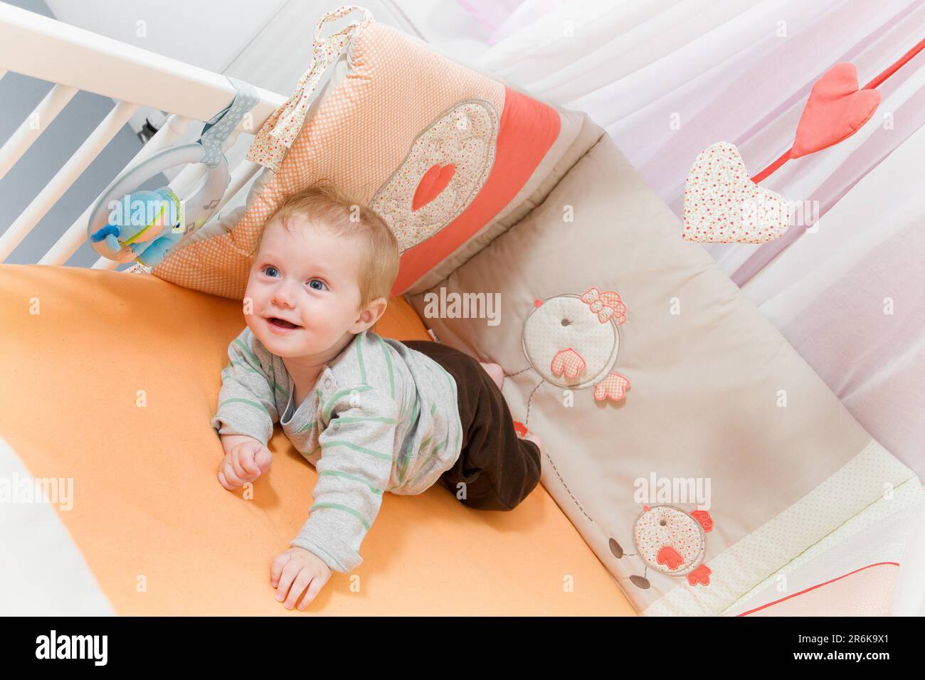 Toddler playing in a cosy cot Stock Photo Alamy