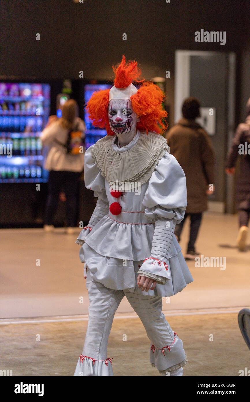 Halloween Makeup Like Pennywise. Street performer clown with a white face.  The look of a man in the guise of IT on a costume cosplay show. Close-up.  Stock Photo