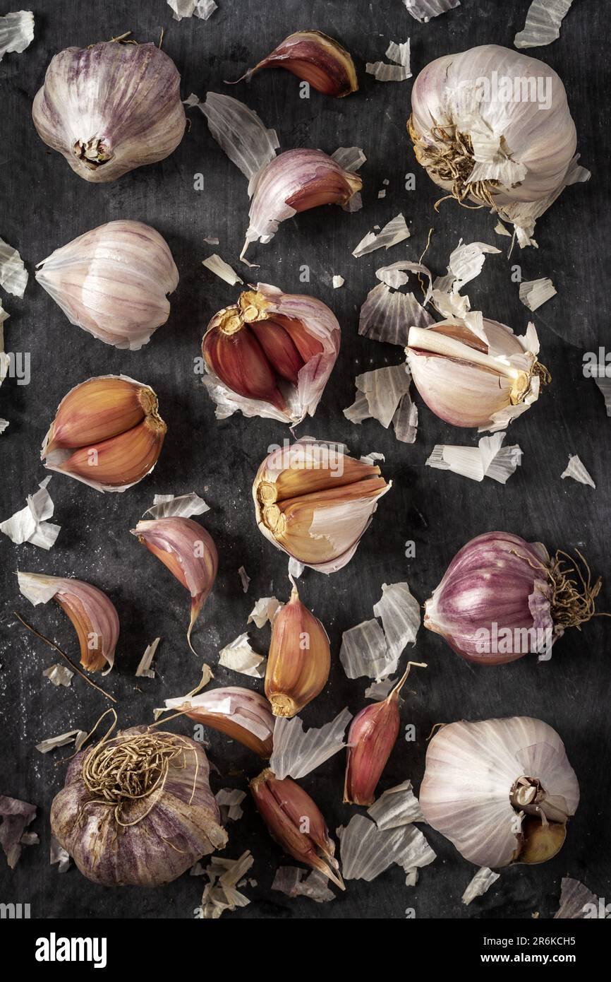 Fresh garlic bulbs and cloves grouped on black background. Flat lay ...