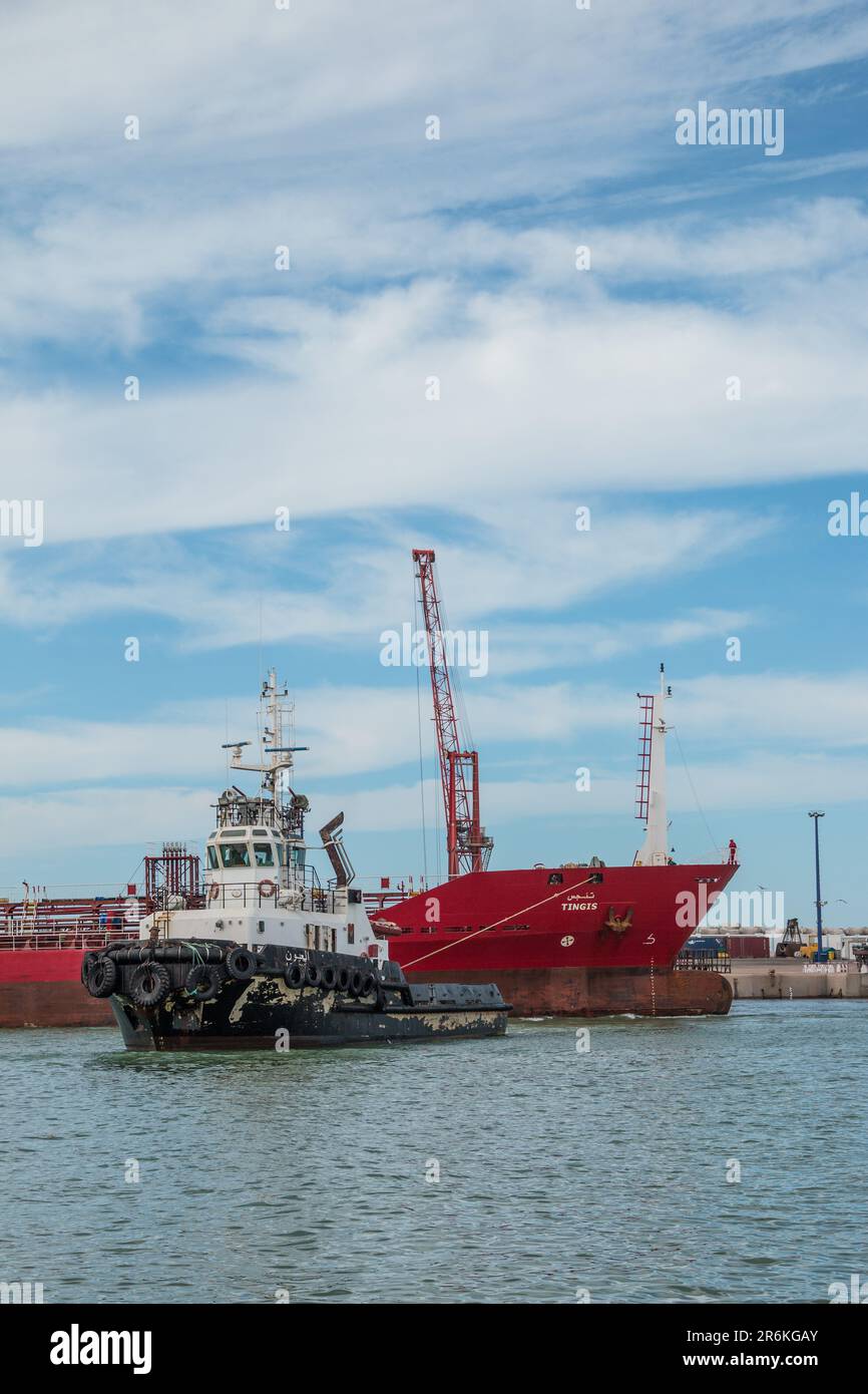 Anchoring the Seas: Tugboat Facilitating Ship Movement at Laayoune Port, Morocco Stock Photo