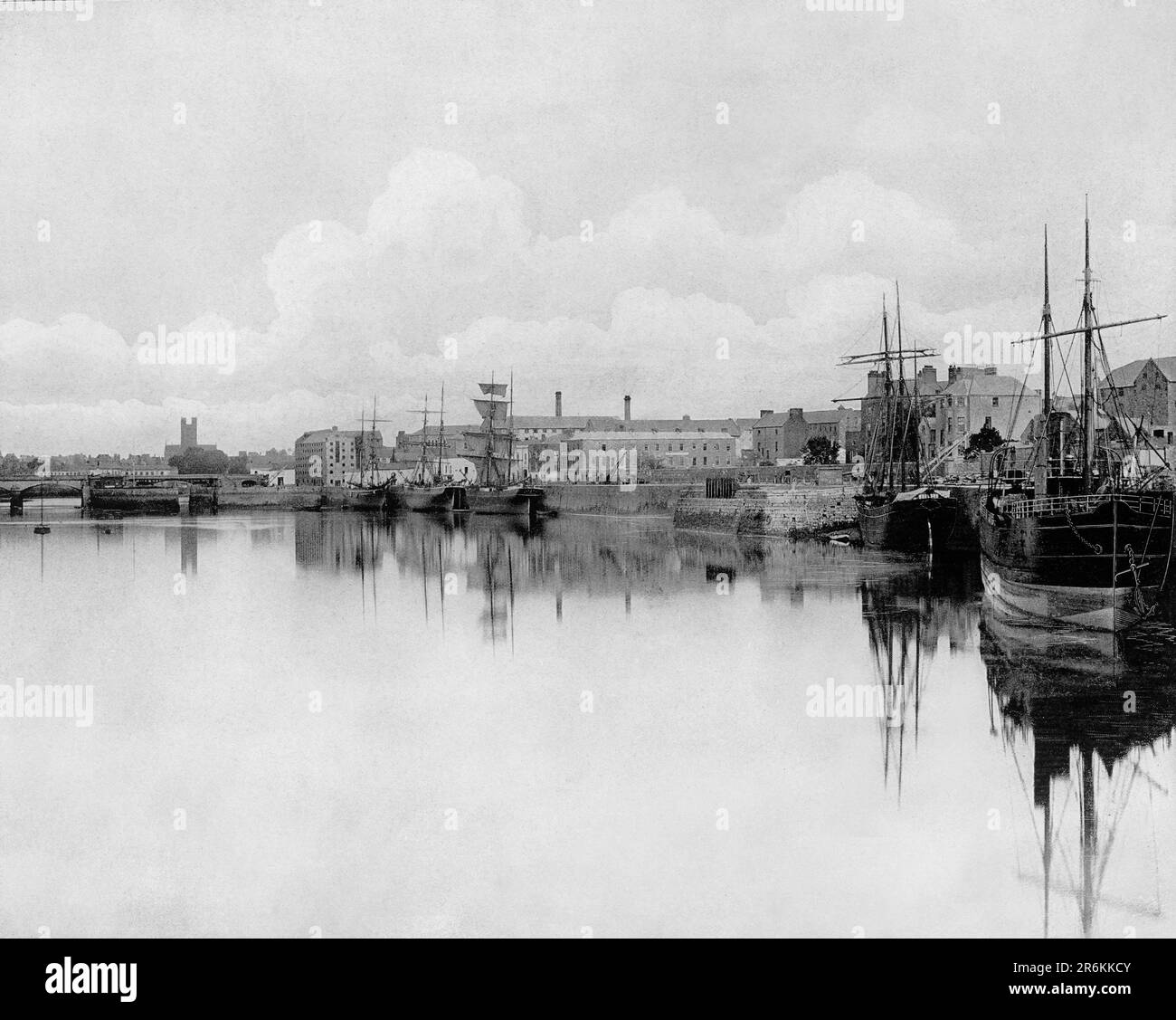 A late 19th century view of shipping moored against the quays on the River Shannon as it flows through Limerick city in County Limerick on the west caost of Ireland. In the late 18th century, Limerick Port established itself as one of Ireland's major commercial ports exporting agricultural produce from one of Ireland's most fertile areas, the Golden Vale, to Britain and America. Stock Photo