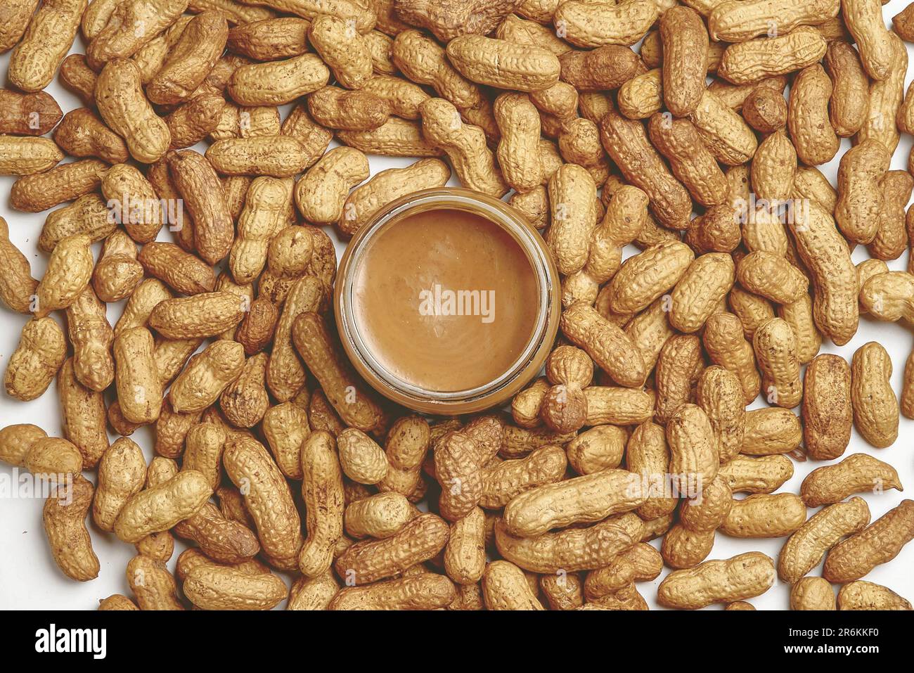 Image of a white background featuring a bowl of peanut kernels and a
