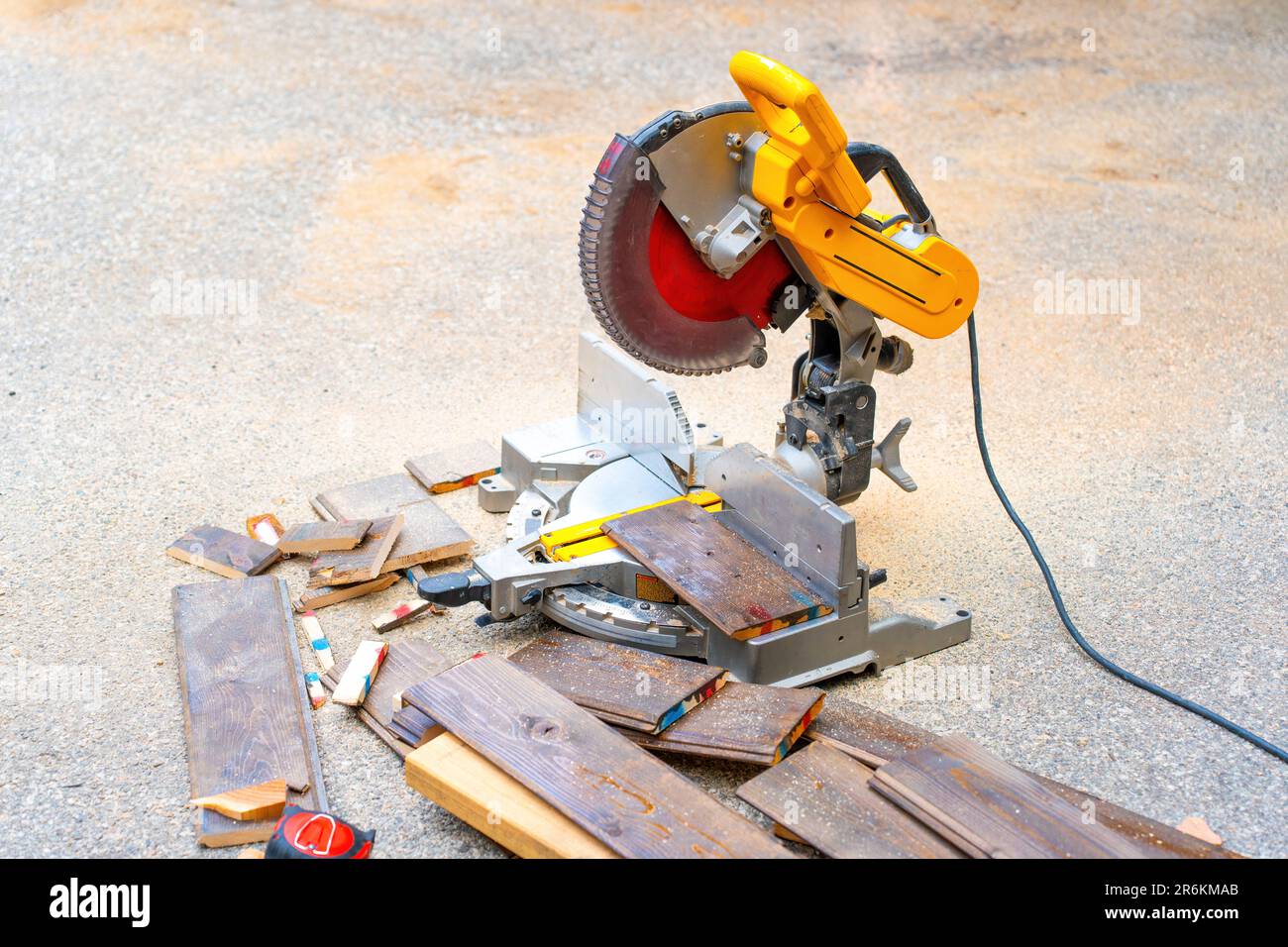 Pile of laminate flooring offcuts and a circular saw sitting idle in an outdoor setting with