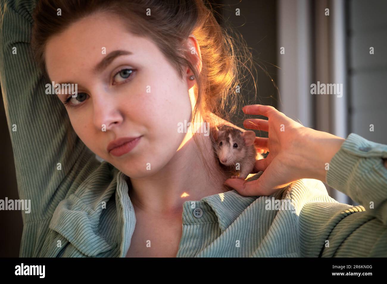 cute rat on the shoulder of a beautiful young girl Stock Photo