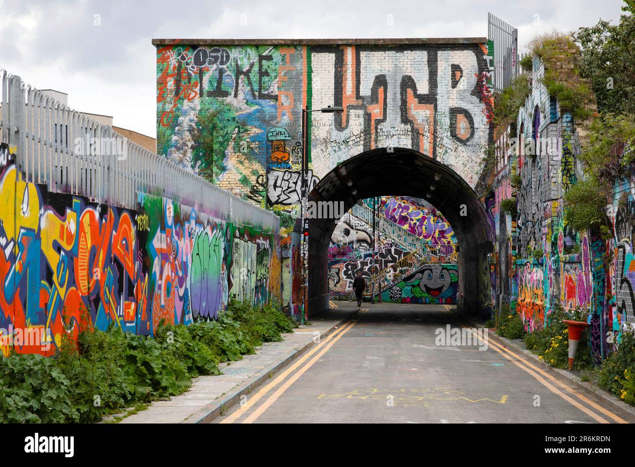 London, UK - May 17 2023: Looking towards a railway bridge in Shoreditch. The gritty inner city area is covered in graffiti. Stock Photo