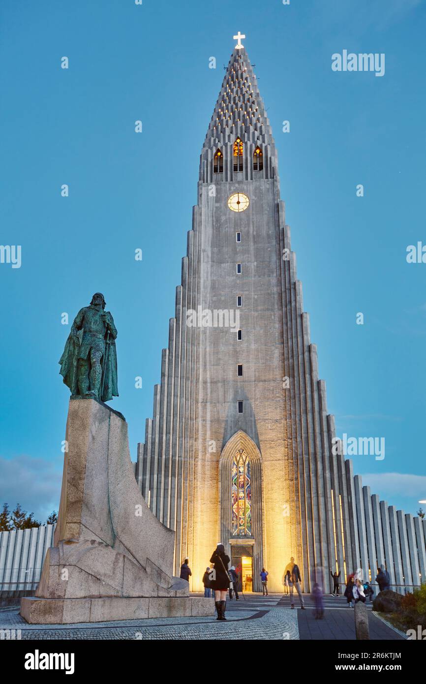 A dusk view of the spire of Hallgrimskirkja Church, fronted by a statue of Leifur Eriksson, founder of Iceland, in central Reykjavik, Iceland Stock Photo