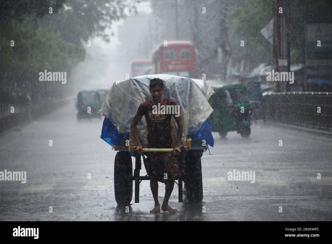 Rickshaw puller carrying passenger when heavy rainfall maid in dhaka, Bangladesh on 22march 2023.Nazmul islam/ alamy live Stock Photo