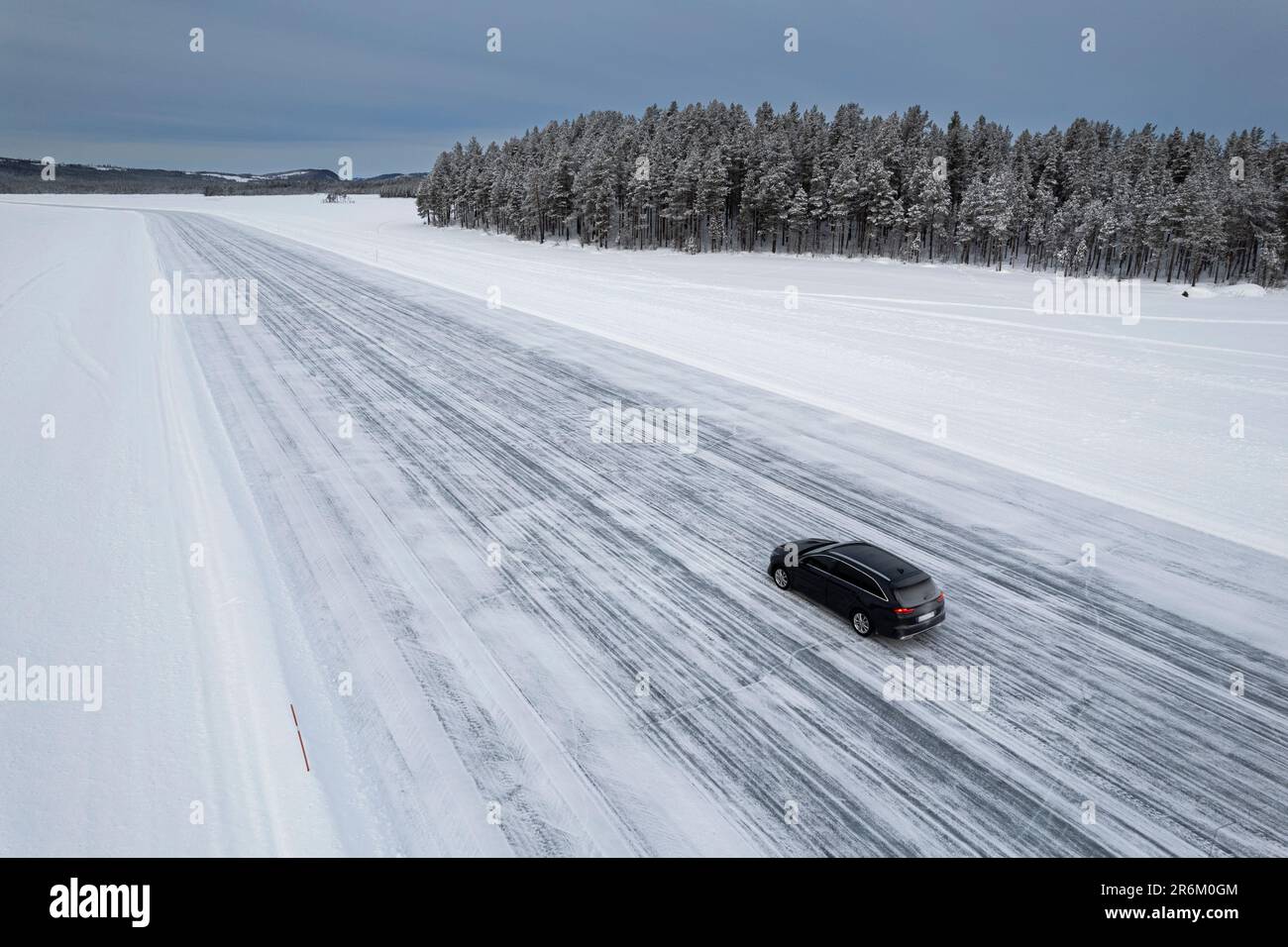 Car traveling on ice track on a frozen lake in the snow covered landscape, Jokkmokk, Norrbotten, Lapland, Sweden, Scaninavia, Europe Stock Photo