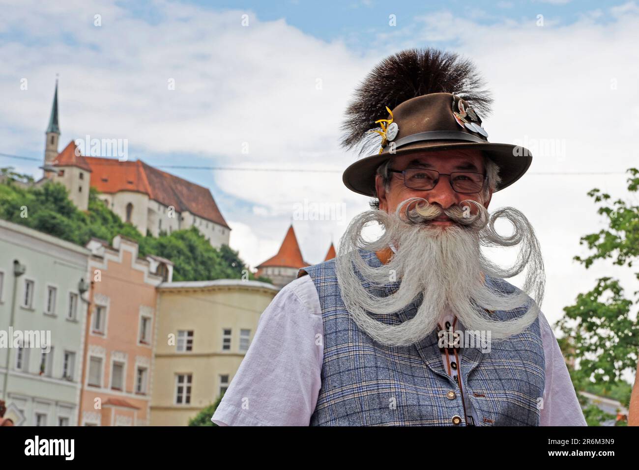 Burghausen, Germany. 10th June, 2023. A competitor stands against the backdrop of the castle during a break on the second day of the World Beard and Mustache Championships. Credit: Uwe Lein/dpa/Alamy Live News Stock Photo