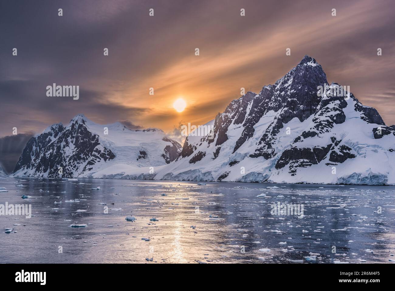 Night Sky with Orange Sun Reflected off Flat Water in Lemaire Channel, Antarctic Peninsula, Antarctica Stock Photo