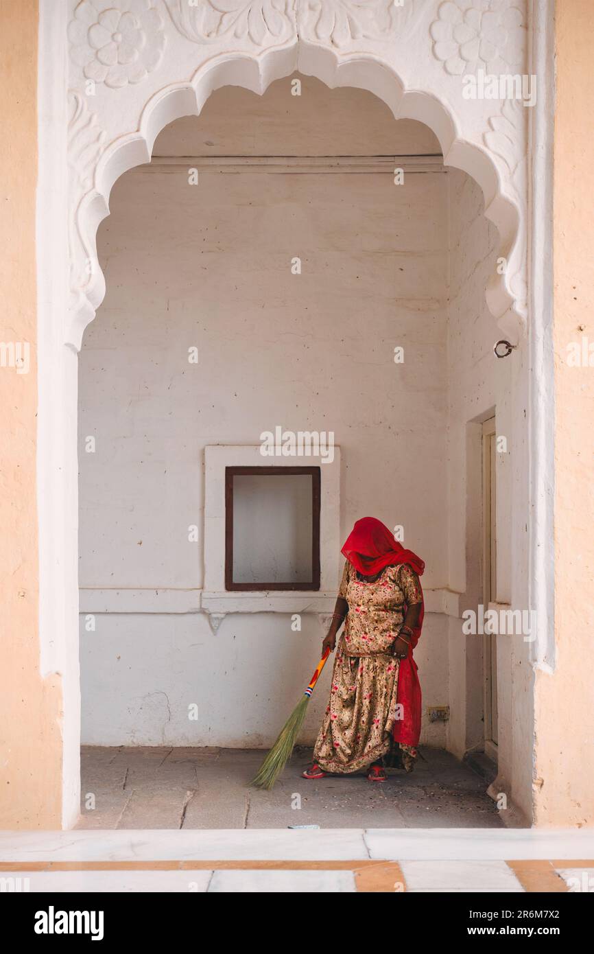 Woman sweeping cleaning the ground in Mehrangarh fort. Jodhpur, Rajasthan, India Stock Photo