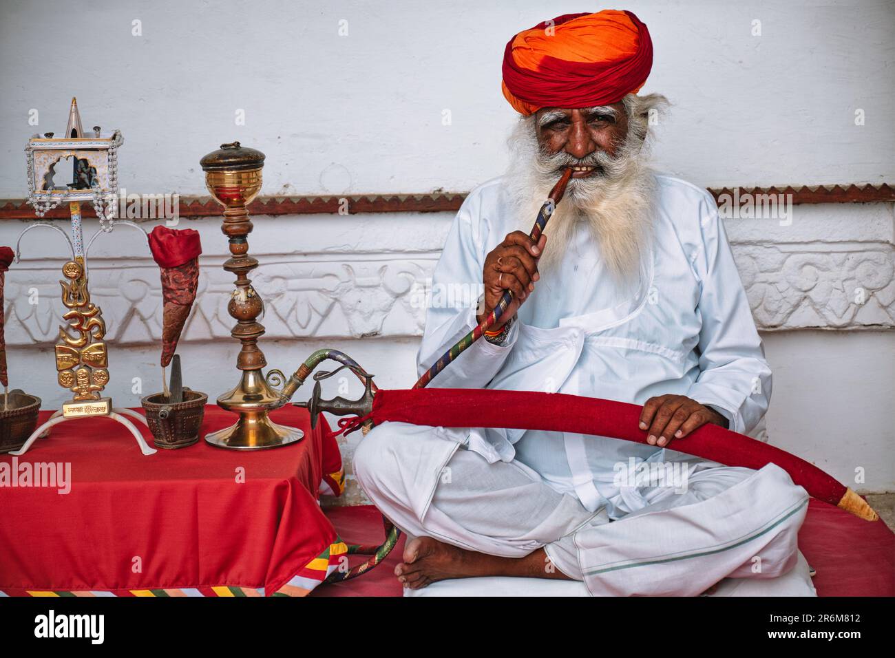 Old Indian man smokes hookah (waterpipe) in Mehrangarh fort Stock Photo