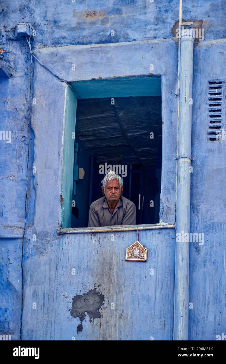 Indian man in window of blue house in Jodhpur, also known as Blue City , India Stock Photo