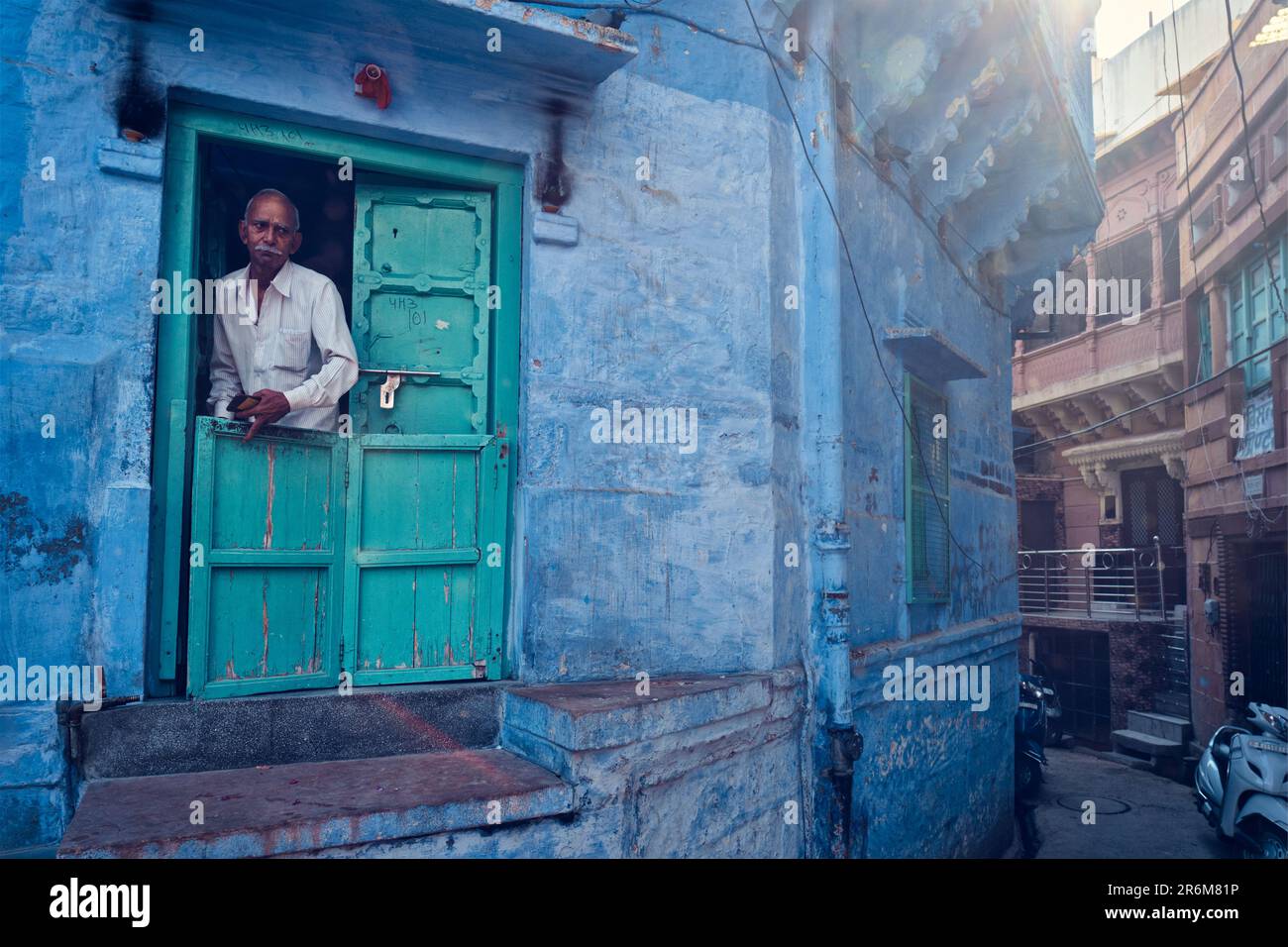 Indian man and his blue house in streets, Jodhpur, Rajasthan, India Stock Photo