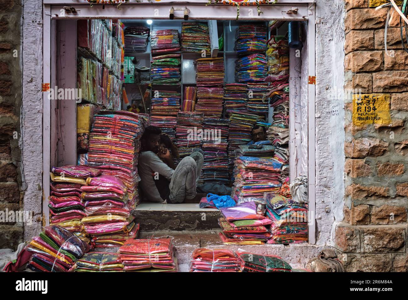 Fabric clothes vendor showing new samples to local women in Sadar