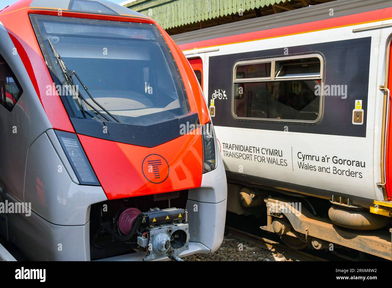 Cardiff, Wales - 8 June 2023: Front of a new train operated by Transport for Wales on the South Wales Metro alongside one of its old diesel trains Stock Photo
