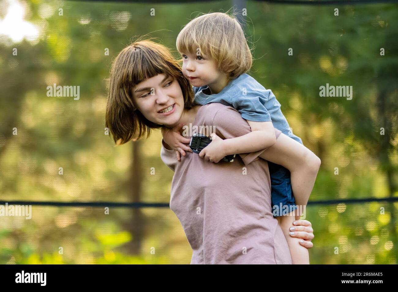 Cute big sister cuddling with her toddler brother. Adorable teenage