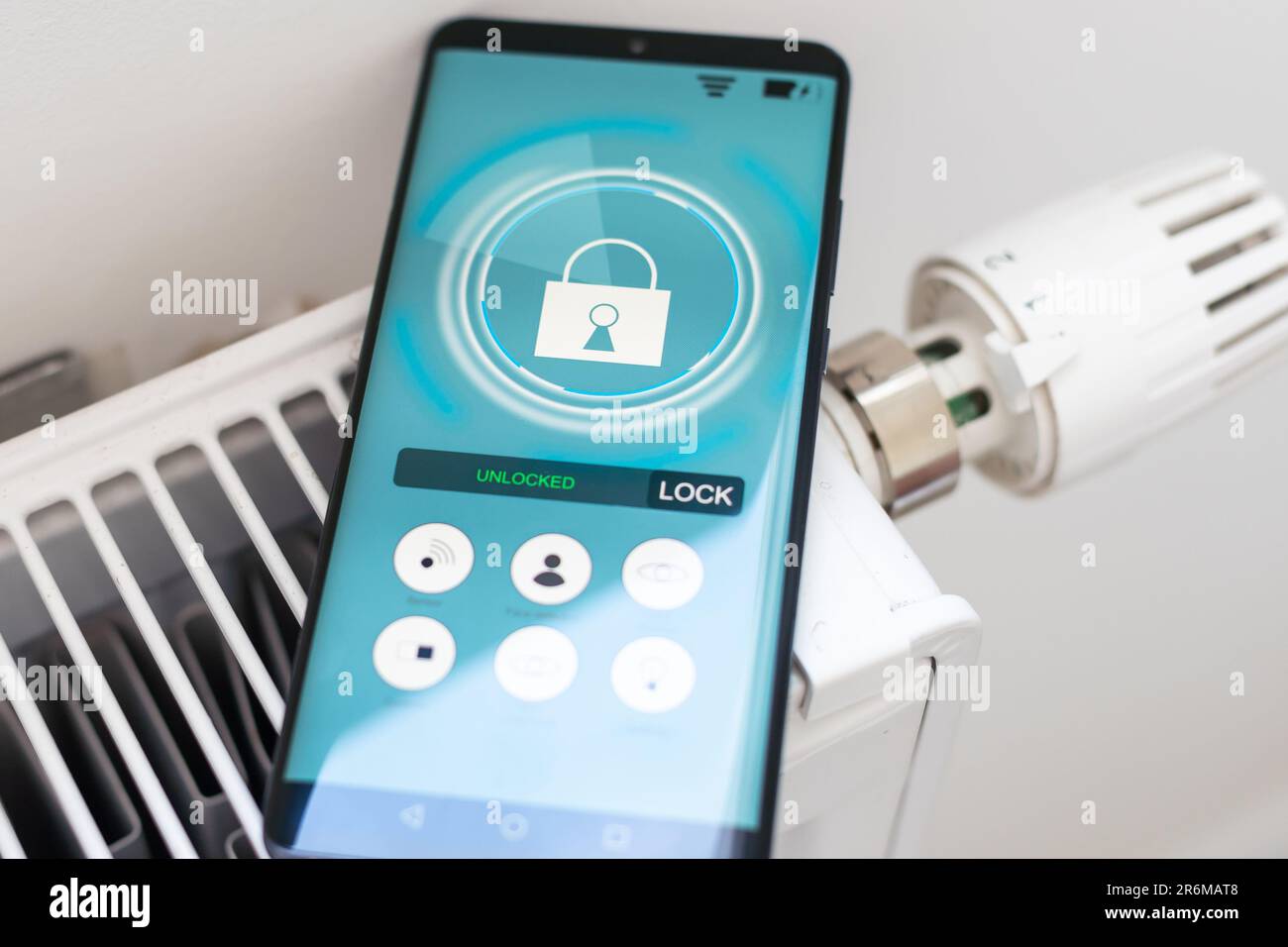 Smart Home: Man Controlling Heating Using App Stock Photo