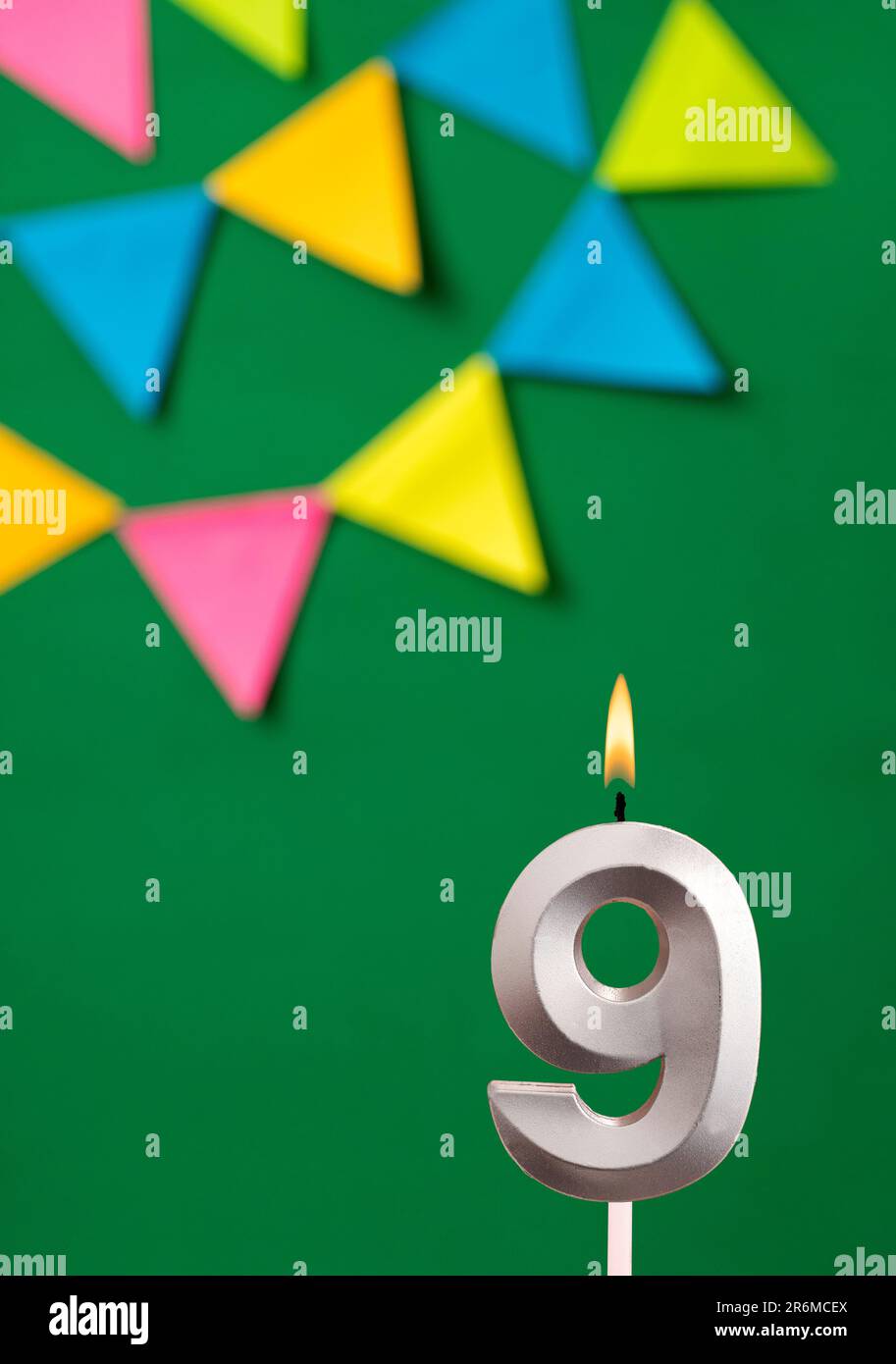 9th Birthday candle - Green anniversary card with pennants Stock Photo