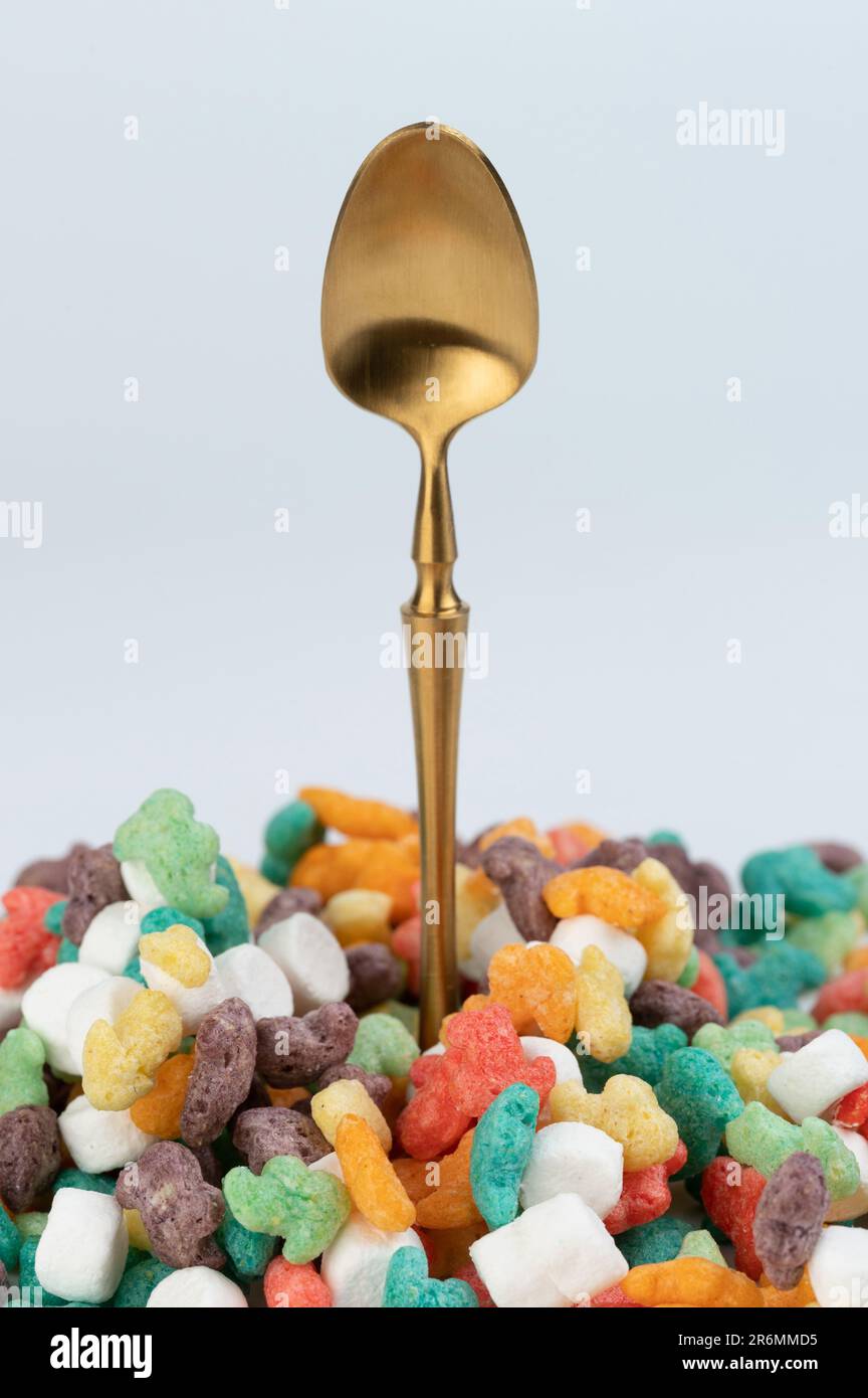 Gold color spoon come from colorful cornflakes macro close up view Stock Photo