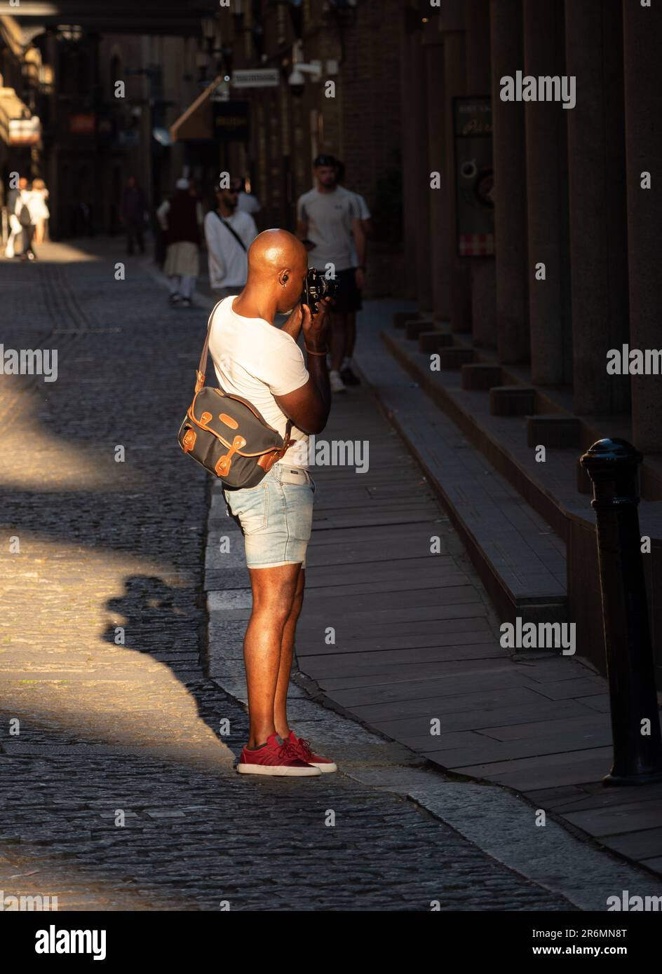 London, England, UK - July 10, 2022: An artist photographer in London who takes pictures of architecture and is lit by a ray of sunlight at golden hou Stock Photo