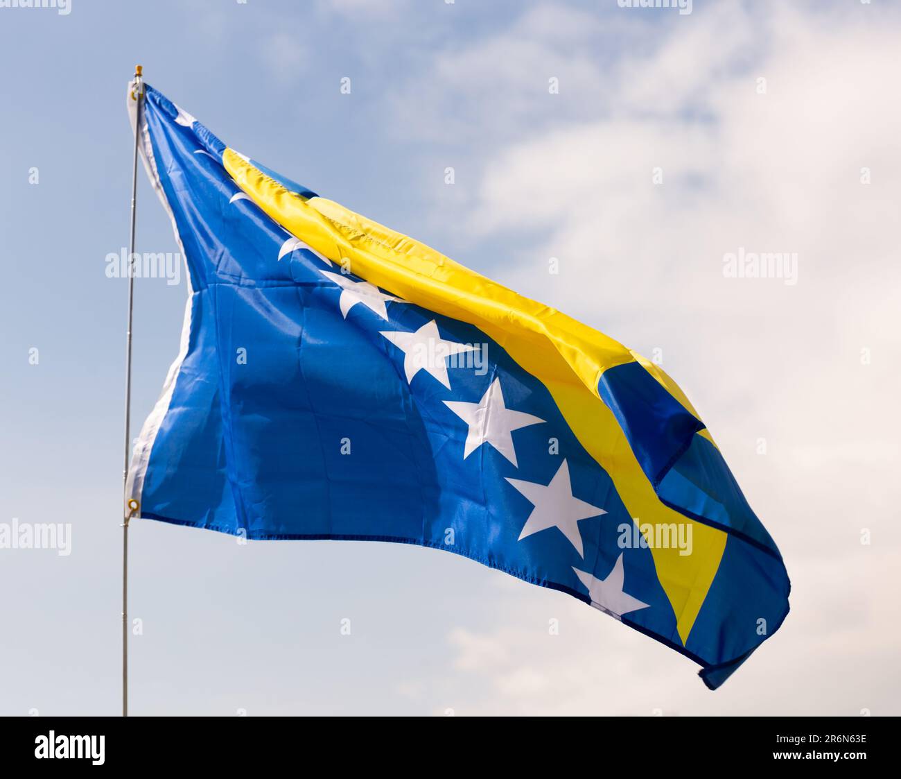 Flag of Bosnia and Herzegovina waving on cloudy sky during daytime ...