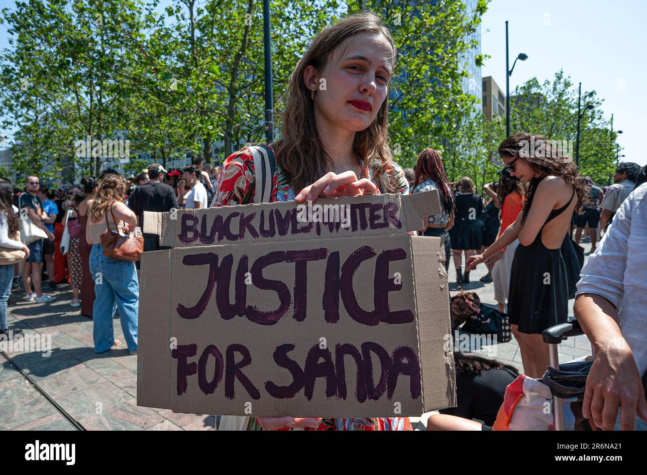 A protester holds a placard expressing her opinion during the Black Lives Matter protest. Black Live Matter protest for Belgium student, Sanda Dia by Moments Contained, a four-meter-high statute of a black woman dressed in jogging pants and trainers looking out over Rotterdam's Stationsplein, the statute is made by British artist Thomas J Price. Black Lives Matter and others, gathered outside Rotterdam's busy Stationsplein, for Sanda Dia, a twenty-year old Belgium university student of colour, who met his death at a fraternity initiation ceremony known as Reuzegom in 2018. The ceremony was tan Stock Photo