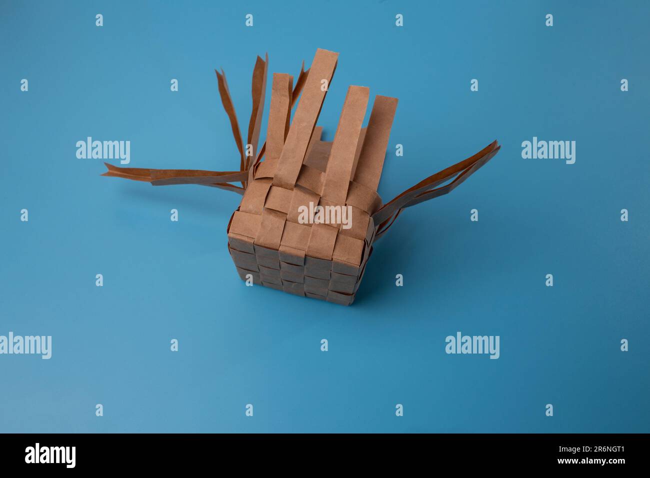 paper basket making process, braided paper stripes, side view Stock